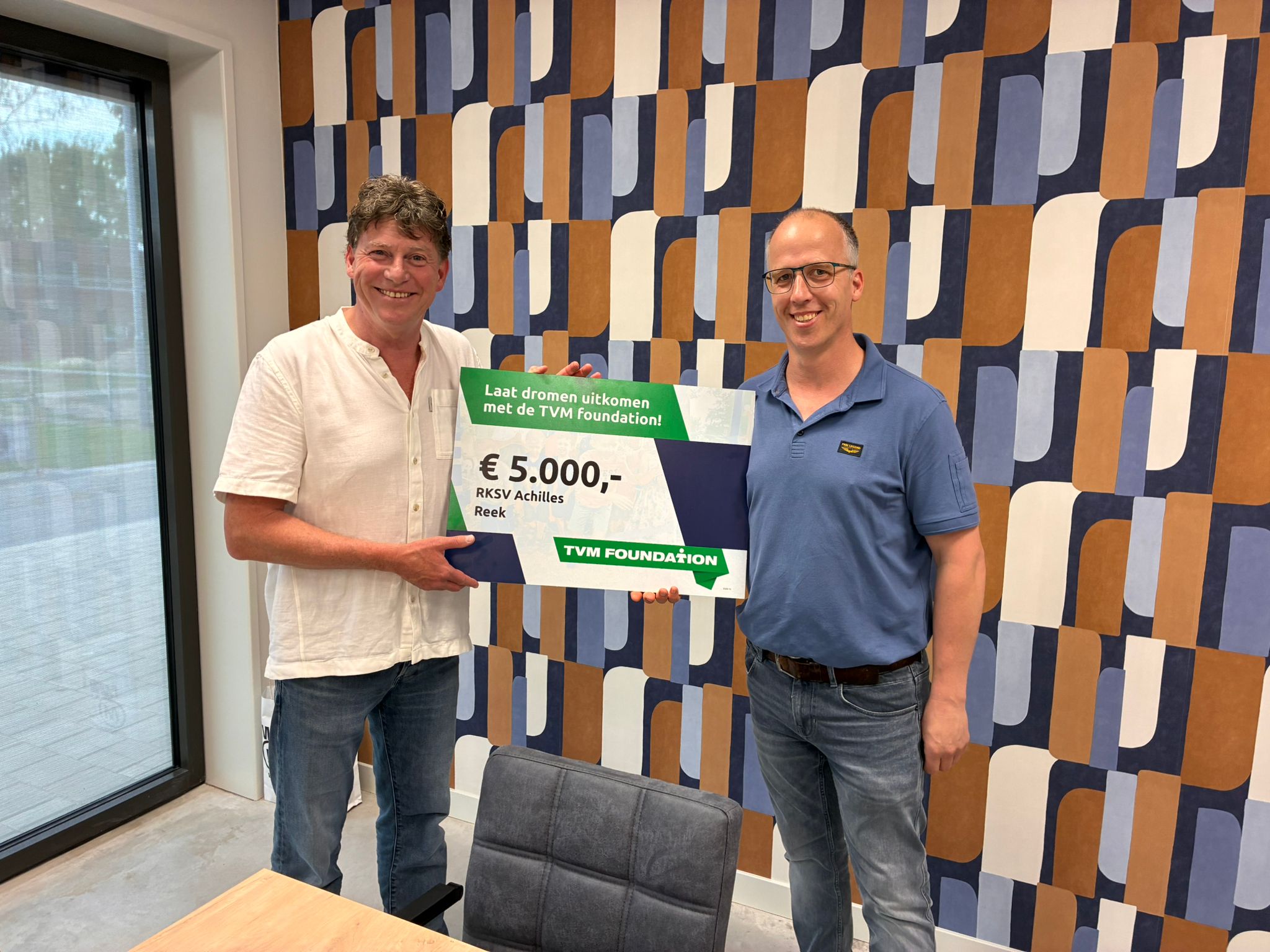 Niels Toonen overhandigt de symbolische cheque aan Sport en Spel Reek