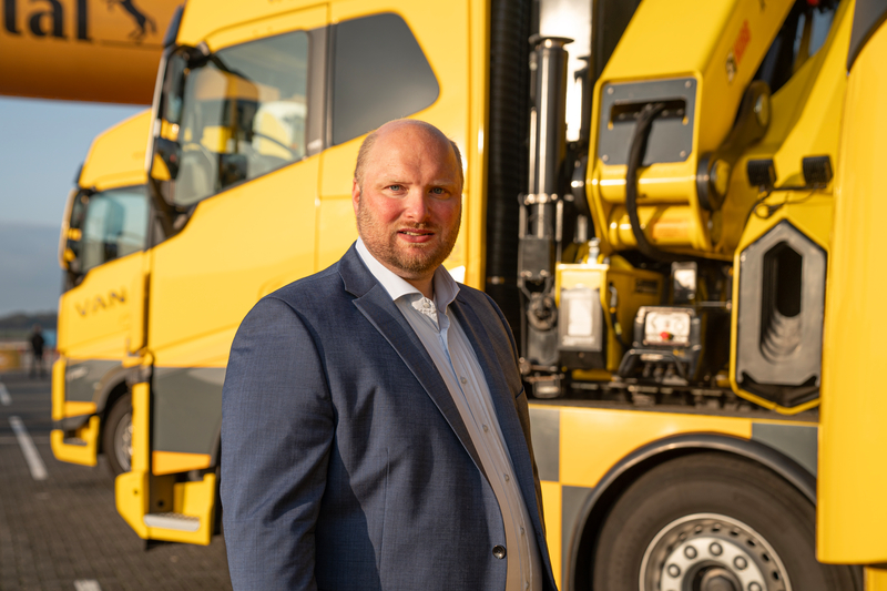 man voor gele vrachtwagen